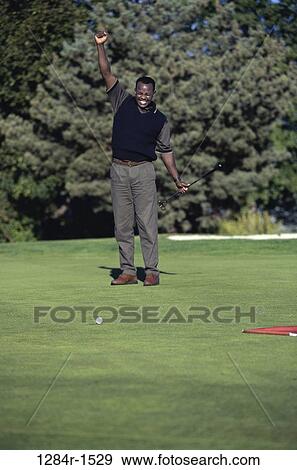 Young man celebrating on a golf course View Large Photo Image Stock Photo - Young man celebrating on a golf course. Fotosearch