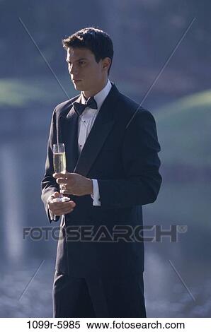 Young man holding a glass of wine View Large Photo Image Stock Photography - Young man holding a glass of wine. Fotosearch