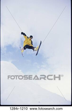 Young man in mid air wearing skis View Large Photo Image Stock Image - Young man in mid air wearing skis. Fotosearch