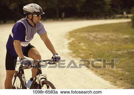Young man sitting on a bicycle View Large Photo Image Stock Image - Young man sitting on a bicycle. Fotosearch
