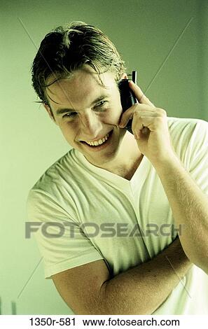 Stock Image - Young man talking on a mobile phone. Fotosearch