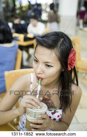 Young woman drinking cold coffee in a restaurant View Large Photo Image Stock Image - Young woman drinking cold coffee in a restaurant. Fotosearch
