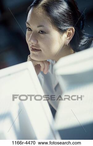 Young woman looking at a computer monitor View Large Photo Image Stock Image - Young woman looking at a computer monitor. Fotosearch