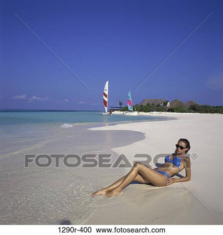 Stock Image - Young woman lying on the beach. Fotosearch