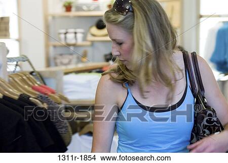 Young woman shopping in a clothing store View Large Photo Image Picture - Young woman shopping in a clothing store. Fotosearch