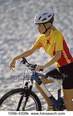 Young woman sitting on a bicycle View Large Photo Image Stock Image - Young woman sitting on a bicycle. Fotosearch