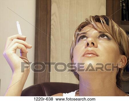Young woman smoking a cigarette View Large Photo Image Stock Photo - Young woman smoking a cigarette. Fotosearch