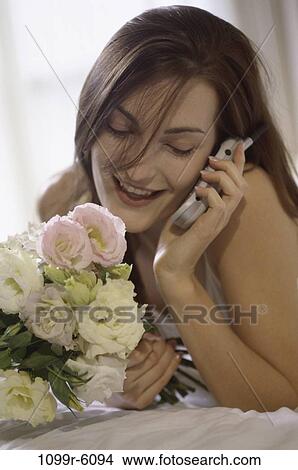 Young woman talking on a mobile phone View Large Photo Image Picture - Young woman talking on a mobile phone. Fotosearch