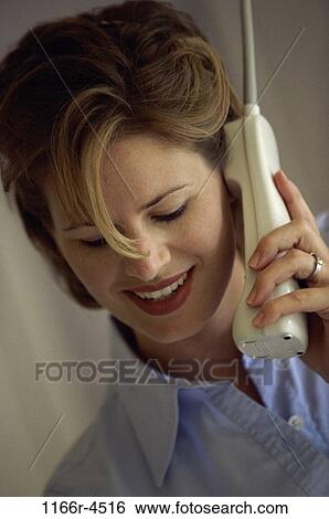 Young woman talking on a telephone View Large Photo Image Stock Photograph - Young woman talking on a telephone. Fotosearch