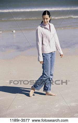 Young woman walking on the beach View Large Photo Image Stock Photo - Young woman walking on the beach. Fotosearch