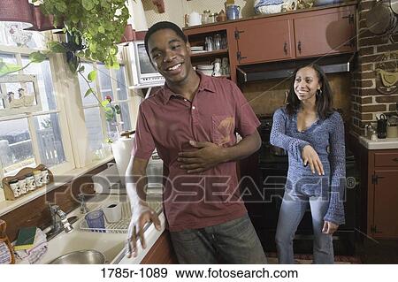 Stock Photo - African American brother and sister laughing in kitchen. Fotosearch