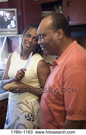 Stock Image - African American couple talking in kitchen. Fotosearch