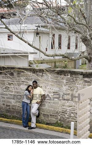 Stock Photograph - African American teenagers leaning against wall outside. Fotosearch