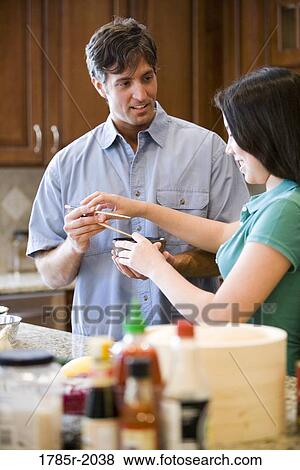 Asian girl showing Caucasian man how to use chopsticks View Large Photo Image Stock Photo - Asian girl showing Caucasian man how to use chopsticks. Fotosearch