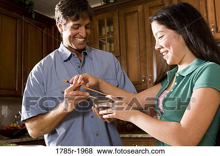 Asian girl showing man how to use chopsticks View Large Photo Image Stock Photo - Asian girl showing man how to use chopsticks. Fotosearch