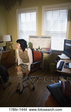 Asian woman sitting on chair in home office View Large Photo Image Picture - Asian woman sitting on chair in home office. Fotosearch