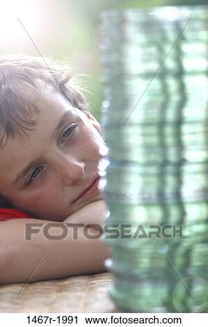 Stock Image - Boy looking at a stack of CD's. Fotosearch
