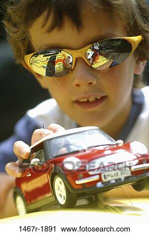 Stock Image - Boy playing with a toy car. Fotosearch