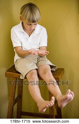 boy sitting and looking at hands and feet View Large Photo Image Stock Photography - boy sitting and looking at hands and feet. Fotosearch