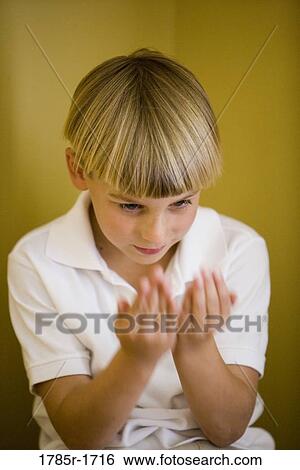 Stock Photograph - Boy staring at hands. Fotosearch