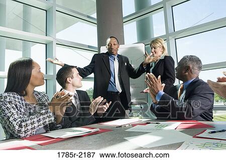 Stock Photo - Business colleagues applauding in a meeting. Fotosearch
