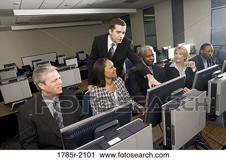 Stock Image - Business colleagues at a computer training seminar. Fotosearch
