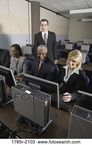 Stock Image - Business colleagues at a computer training seminar. Fotosearch