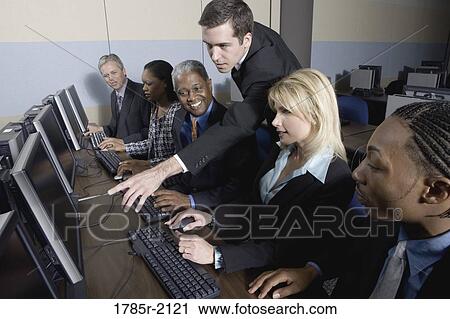 Stock Image - Business colleagues at a computer training seminar. Fotosearch