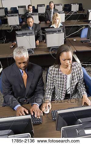 Stock Photograph - Business colleagues at a computer training seminar. Fotosearch