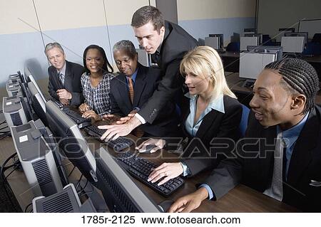 Stock Photography - Business colleagues at a computer training seminar. Fotosearch