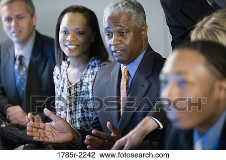 Business colleagues sitting in a row View Large Photo Image Stock Image - Business colleagues sitting in a row. Fotosearch