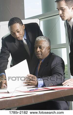 Business men reviewing paperwork View Large Photo Image Stock Image - Business men reviewing paperwork. Fotosearch