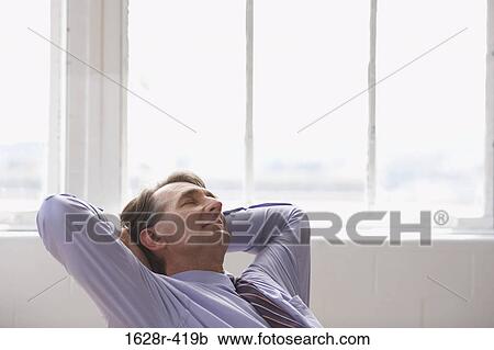 Businessman with his hands behind his head View Large Photo Image Stock Image - Businessman with his hands behind his head. Fotosearch
