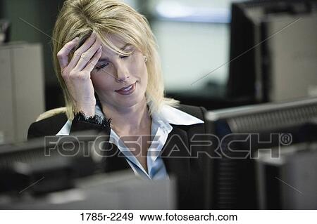 Businesswoman suffering from a headache working in an office View Large Photo Image Stock Photo - Businesswoman suffering from a headache working in an office. Fotosearch