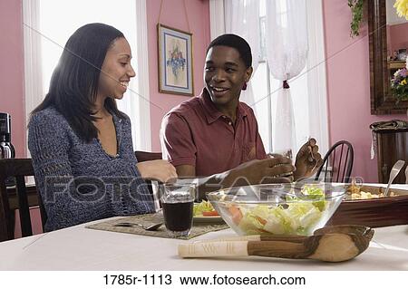 Cheerful brother and sister sitting at dining table View Large Photo Image Stock Image - Cheerful brother and sister sitting at dining table. Fotosearch