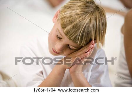 Picture - Close-up of a boy pretending to sleep. Fotosearch
