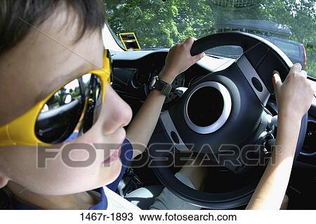 Stock Image - Close-up of a boy sitting in a car. Fotosearch