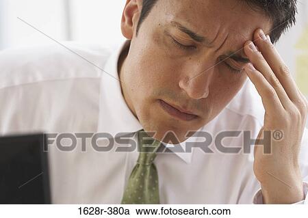 Close-up of a businessman suffering from a headache View Large Photo Image Stock Image - Close-up of a businessman suffering from a headache. Fotosearch