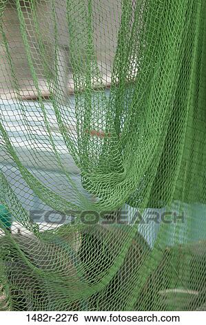 Stock Photograph - Close-up of a commercial fishing net drying. Fotosearch