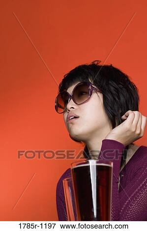 Close-up of a contemplative young Asian woman View Large Photo Image Stock Photo - Close-up of a contemplative young Asian woman. Fotosearch