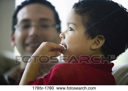 Stock Image - Close-up of a little boy with his father in the background. Fotosearch