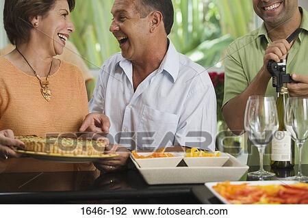 Close-up of a mature couple looking at each other with a mature man unscrewing the cork of a wine bottle View Large Photo Image Stock Image - Close-up of a mature couple looking at each other with a mature man unscrewing the cork of a wine bottle. Fotosearch