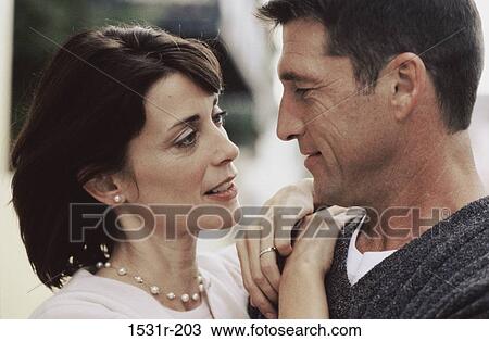 Stock Image - Close-up of a mid adult couple looking at each other. Fotosearch