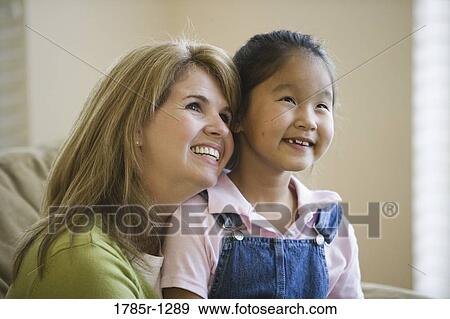 Stock Photo - Close-up of a mother and daughter smiling. Fotosearch