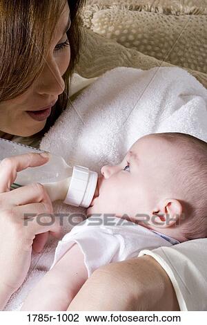 Close-up of a mother bottle-feeding baby View Large Photo Image Stock Image - Close-up of a mother bottle-feeding baby. Fotosearch