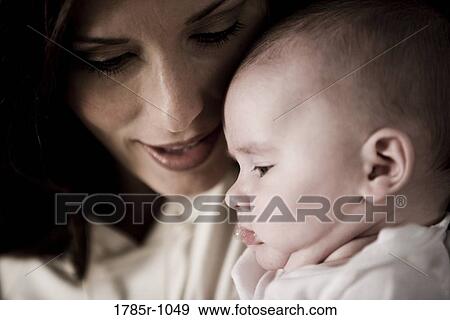 Close-up of a mother holding baby View Large Photo Image Stock Photo - Close-up of a mother holding baby. Fotosearch