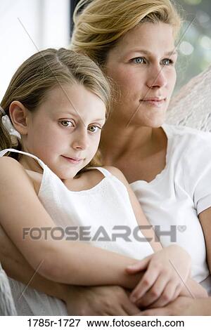 Stock Photo - Close-up of a mother with her daughter sitting in a hammock. Fotosearch