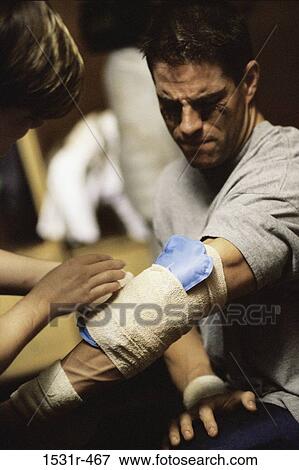 Close-up of a person dressing a man's injured hand View Large Photo Image Stock Photo - Close-up of a person dressing a man's injured hand. Fotosearch