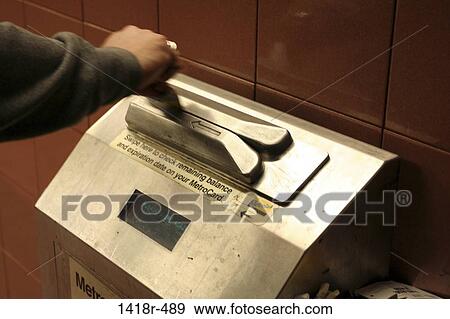 Stock Photo - Close-up of a person swiping a metro card. Fotosearch