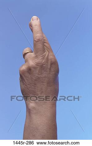 Close-up of a person's fingers crossed View Large Photo Image Stock Photograph - Close-up of a person's fingers crossed. Fotosearch